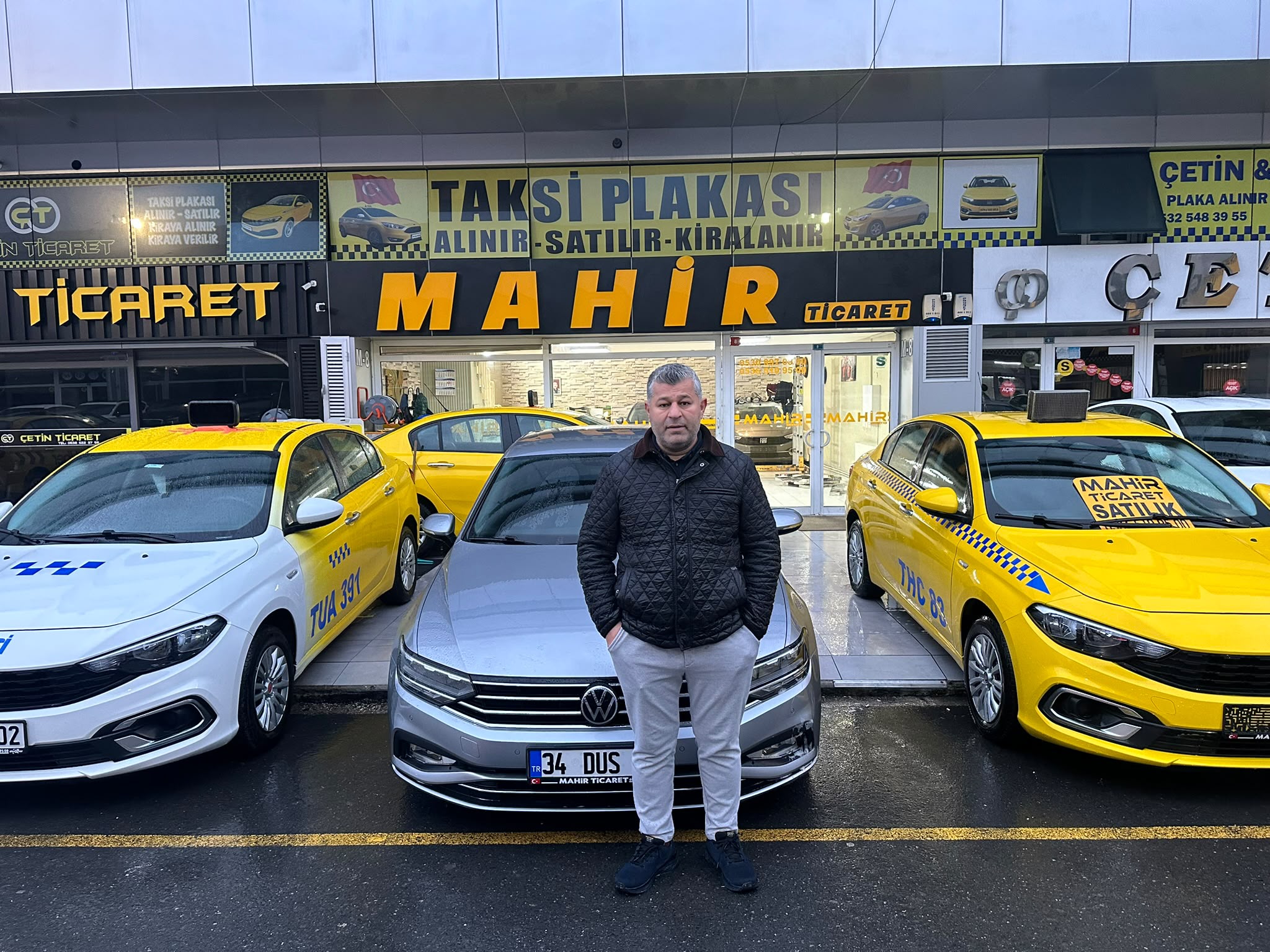 Mahir Ticaret galerisi önünde araçlar ve işletme temsilcisi